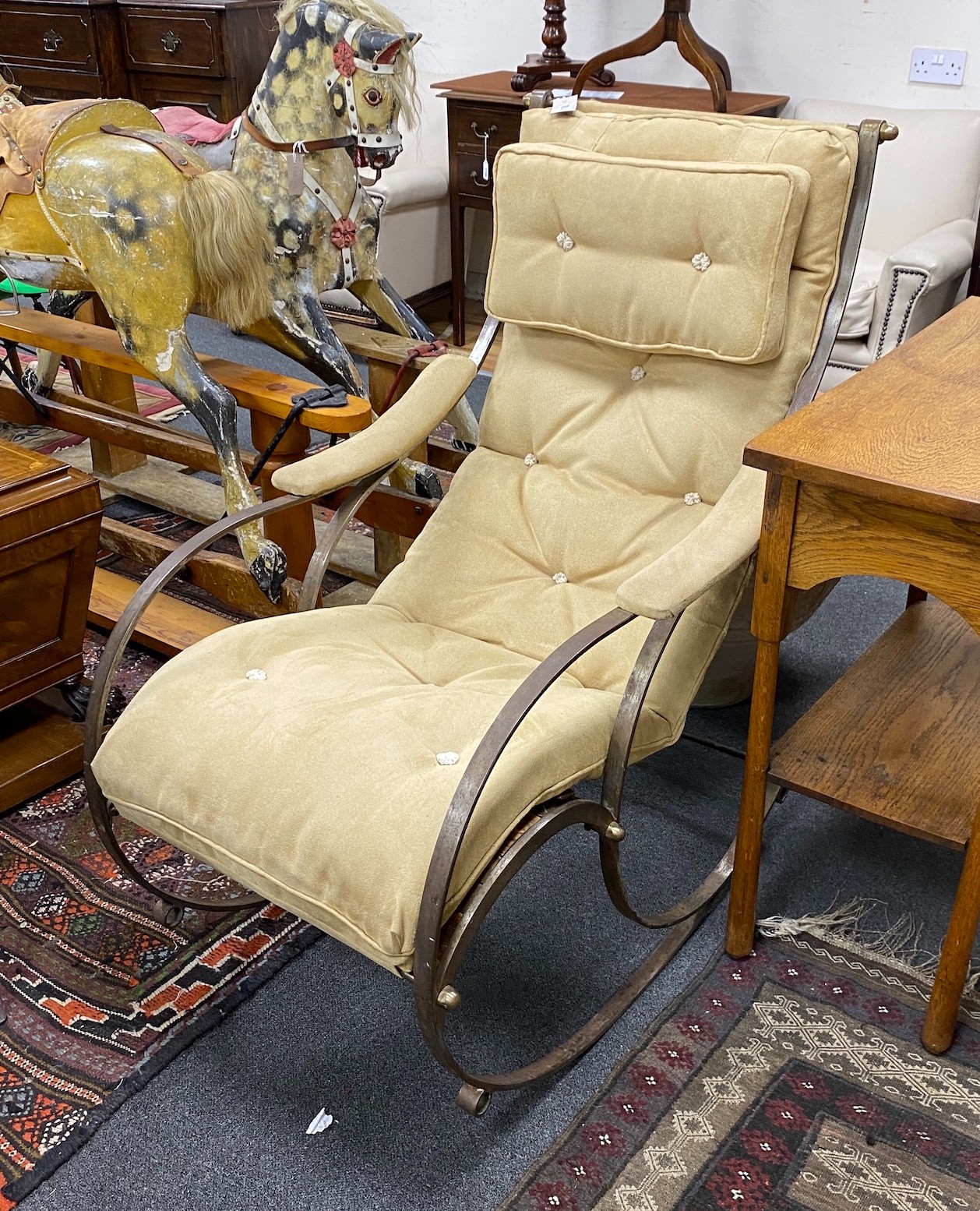 A wrought iron and suede rocking armchair, width 62cm, depth 90cm, height 107cm
